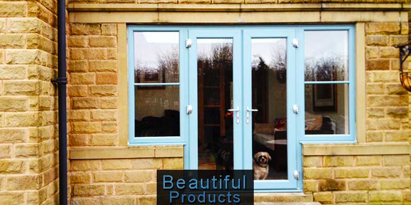 stunning replacement double frenceh doors in aqua blue with atached side windows on a stone built home